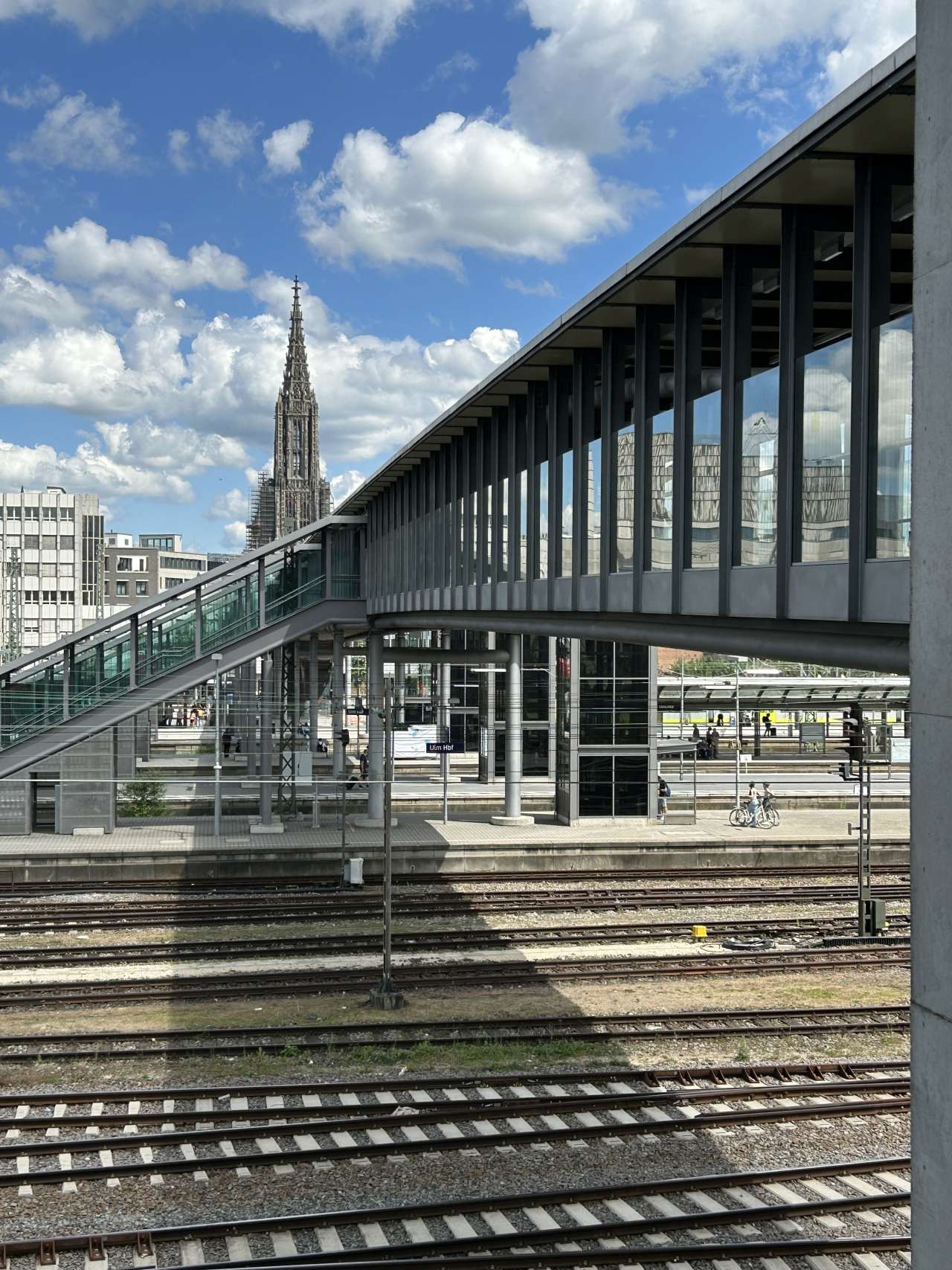 Außenansicht Bahnhofsteg mit Münster im Hintergrund.