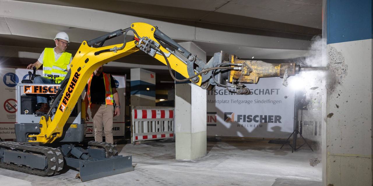 Mitarbeiter sitzt auf Bagger.